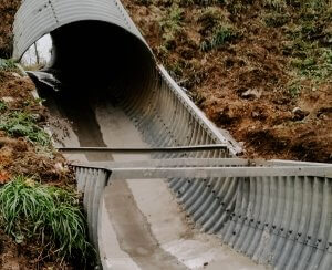 A culvert is exposed to reveal a damaged floor needing repair.