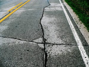 Multiple large cracks on a road.