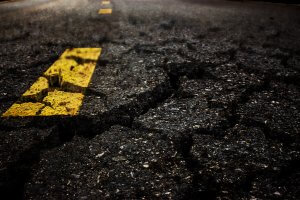 A close-up photo of cracked asphalt.